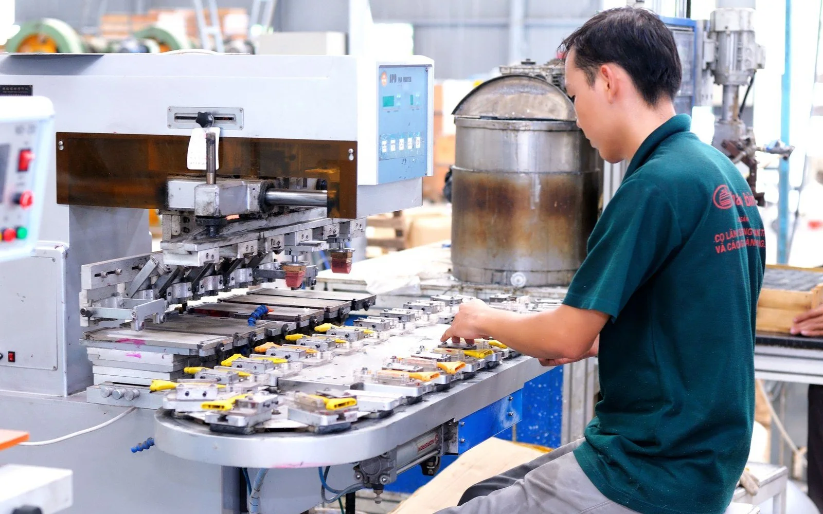 A worker operating production machinery in a manufacturing workshop