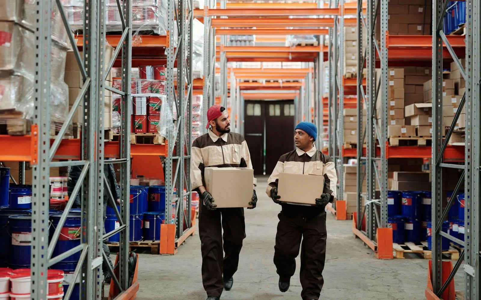 Warehouse workers moving cartons in a storage aisle